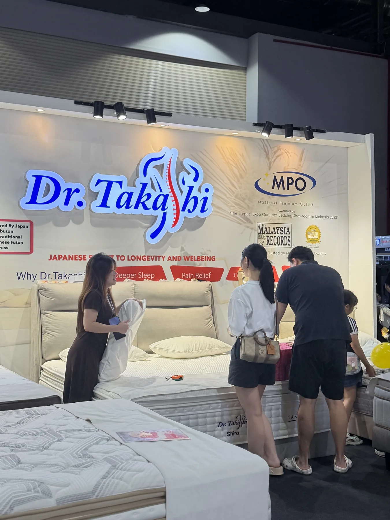 Dr. Takashi exhibition booth welcoming visitors to try the mattress collection.