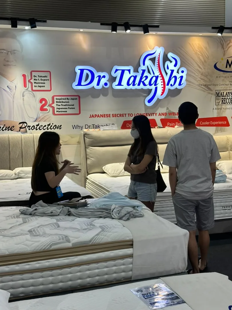 The Dr. Takashi exhibition team assisting visitors with mattress selection.