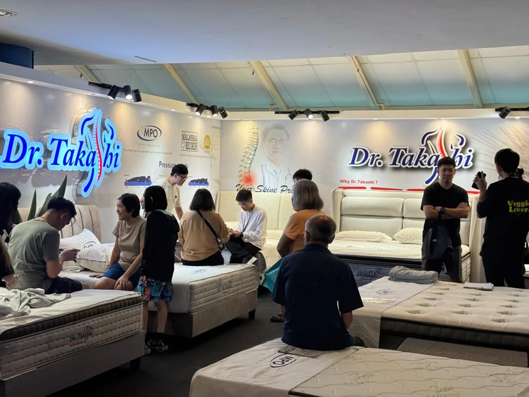 Visitors comparing Dr. Takashi mattresses during a home and living fair.